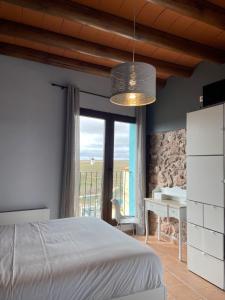 a bedroom with a bed and a desk and a window at Hotel Boutique Malanquilla Inedita in Malanquilla