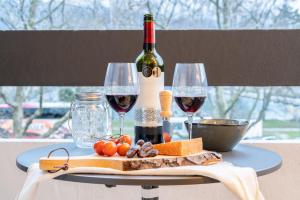 een tafel met twee glazen wijn en kaas bij LOFT am See - dein Zuhause direkt am Wasser - self checkin - Bitcoin accepted in Thun