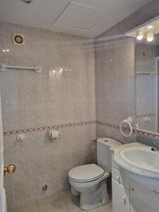 y baño con aseo y lavamanos. en One bedroom 7th floor apartment with amazing views, en Fuengirola