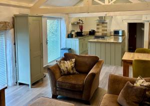 a living room with two chairs and a kitchen at Lavender Barn in Newquay