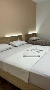 duas camas com lençóis brancos e toalhas em HOTEL AMADO em Aracaju