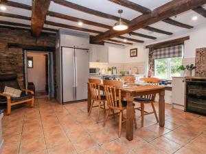 a kitchen with a table and chairs and a refrigerator at The Brewhouse in Church Stretton