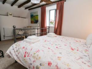 a bedroom with a bed with a floral comforter at The Brewhouse in Church Stretton