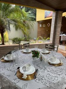 einen Tisch mit einem weißen Tischtuch, Tellern und Gläsern in der Unterkunft POUSADA CABANA DO PARQUE in Mateiros