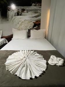 Una cama blanca con una gran sombrilla blanca. en POUSADA CABANA DO PARQUE en Mateiros