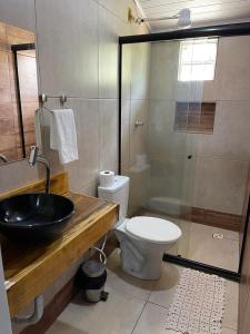 een badkamer met een wastafel, een toilet en een douche bij POUSADA CABANA DO PARQUE in Mateiros