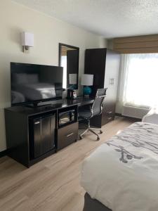 a hotel room with a bed and a desk and a television at Sleep Inn Staunton in Staunton