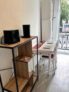 a room with a television and a table and a balcony at Studio Duquesne 1/2 pers in Nantes