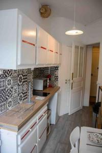 a kitchen with white cabinets and a counter top at Studio Duquesne 1/2 pers in Nantes