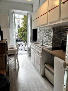 a kitchen with white cabinets and a table and a window at Studio Duquesne 1/2 pers in Nantes