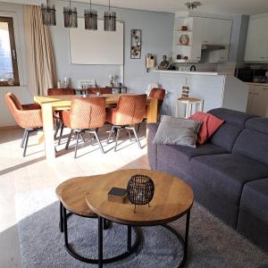 a living room with a couch and a table at Appartement Residentie Amadeus met garage in Sint-Idesbald