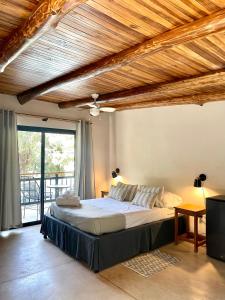 - une chambre avec un grand lit et un plafond en bois dans l'établissement Believe Surf & Yoga Lodge Santa Teresa, à Santa Teresa