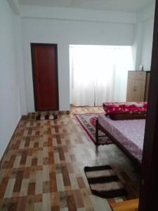 een kamer met een bed en een raam erin bij Areca Holiday Apartment in Siliguri