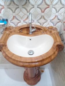 uma casa de banho com um lavatório feito de madeira em Areca Holiday Apartment em Siliguri