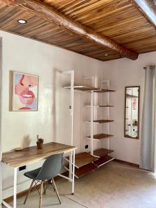 een kamer met een bureau en een boekenplank bij Believe Surf & Yoga Lodge Santa Teresa in Santa Teresa Beach