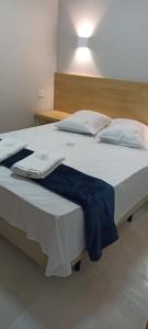 Una cama grande con una manta azul. en Hotel New Space, en São Paulo