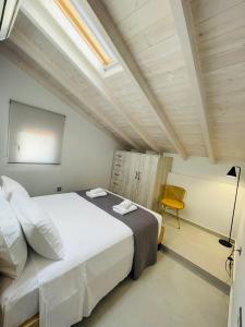 a bedroom with a large white bed and a chair at Room in Apartment - Villa Rodelia nr4 in Roda in Roda