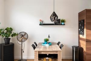 - une salle à manger avec une table et des chaises en bois dans l'établissement De Schelp 18, Garden & Free Parking, à Zandvoort