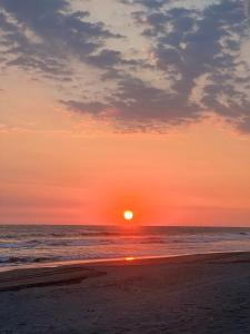 een zonsondergang op een strand met de oceaan bij Cabañas Casa de Agua in Boca del cielo