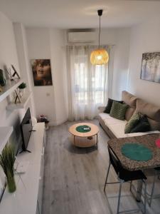マラガにあるAcogedor apartamento cerca del centro histórico de Málagaのリビングルーム(ソファ、テーブル付)