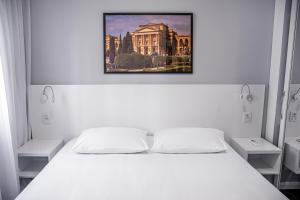 a bedroom with a white bed with a picture above it at Mercure Sao Paulo Berrini in Sao Paulo +129 photos
