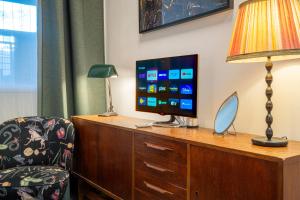 a hotel room with a desk with a television and a chair at Stylish Private Studio Close to City in Amsterdam
