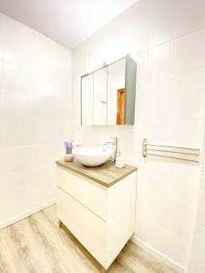 een witte badkamer met een wastafel en een spiegel bij San Gil in Cenes de la Vega
