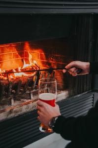 a person holding a glass of wine in front of a fire at Suite 202 - Destination Mont-Orford in Magog-Orford