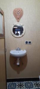baño con lavabo y espejo en la pared en da housa hostel, en Tahliouine