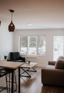 a living room with a couch and a table at Suite 202 - Destination Mont-Orford in Magog-Orford