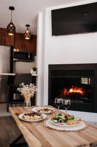 una mesa con dos platos de comida y copas de vino en Suite 203 - Destination Mont-Orford en Magog-Orford