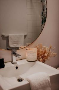 w łazience znajduje się umywalka ze świecą i lustrem w obiekcie Suite 203 - Destination Mont-Orford w mieście Magog-Orford