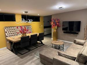 een woonkamer met een eettafel en een tv bij Luxe woning Bubbles! Met airco en Parkeren op eigen grond in Castricum