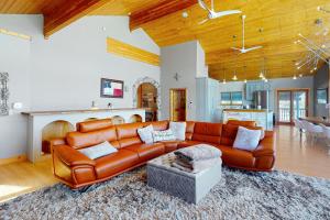 a living room with a brown leather couch at Le Chalet Bleu in Angel Fire