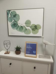 una cómoda blanca con una foto y una planta en ella en Hipica Home Granada Center en Granada