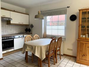uma cozinha com mesa e cadeiras num quarto em Semi-detached house, Nessmersiel em Neßmersiel