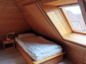 uma pequena cama num quarto com uma janela em Semi-detached house, Nessmersiel em Neßmersiel