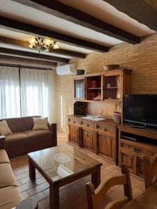 a living room with a couch and a tv at El Rincon del Moncayo in Vera de Moncayo