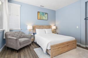 a bedroom with a bed and a chair at Olivia Oasis in Oxnard