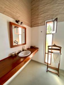 a bathroom with a sink and a mirror and a window at Casa en Haras Bettina in Mercedes