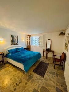 a bedroom with a large bed with a blue blanket at La Maison Bleue in Dar Salah Bey