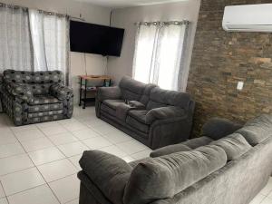 Sala de estar con 2 sofás y TV en Casa confortable cerca de playa, en Ciudad Madero