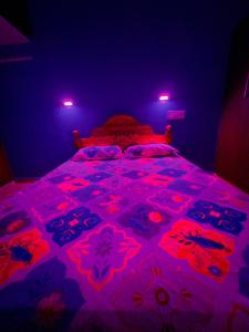 a bedroom with a bed with pink lights on it at SS Home Stay Accomodation in Tiruvannāmalai