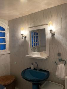 a bathroom with a blue sink and a mirror at La Maison Bleue in Dar Salah Bey