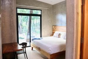 Schlafzimmer mit einem Bett, einem Tisch und einem Fenster in der Unterkunft hotelitos dos hijas in Playa Grande