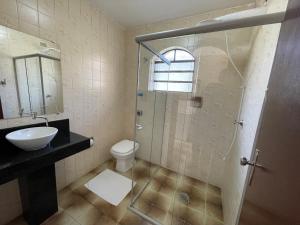 La salle de bains est pourvue d'une douche en verre et de toilettes. dans l'établissement Hotel Fazenda São Matheus, à Serra Negra