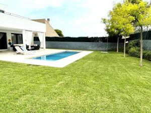 a backyard with a swimming pool and a grass yard at Chalet Irlanda Luxury in Peñíscola
