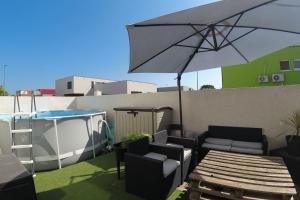 une terrasse avec une table et un parasol dans l'établissement Maison d'Elina à 3 minutes de la mer, à Vic-la-Gardiole