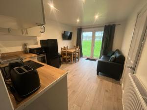 a kitchen and living room with a table and chairs at Mulberry Holiday Home in Great Yarmouth