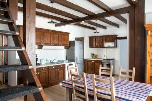 a kitchen with wooden cabinets and a table and chairs at SáBa Vendégház in Tapolca